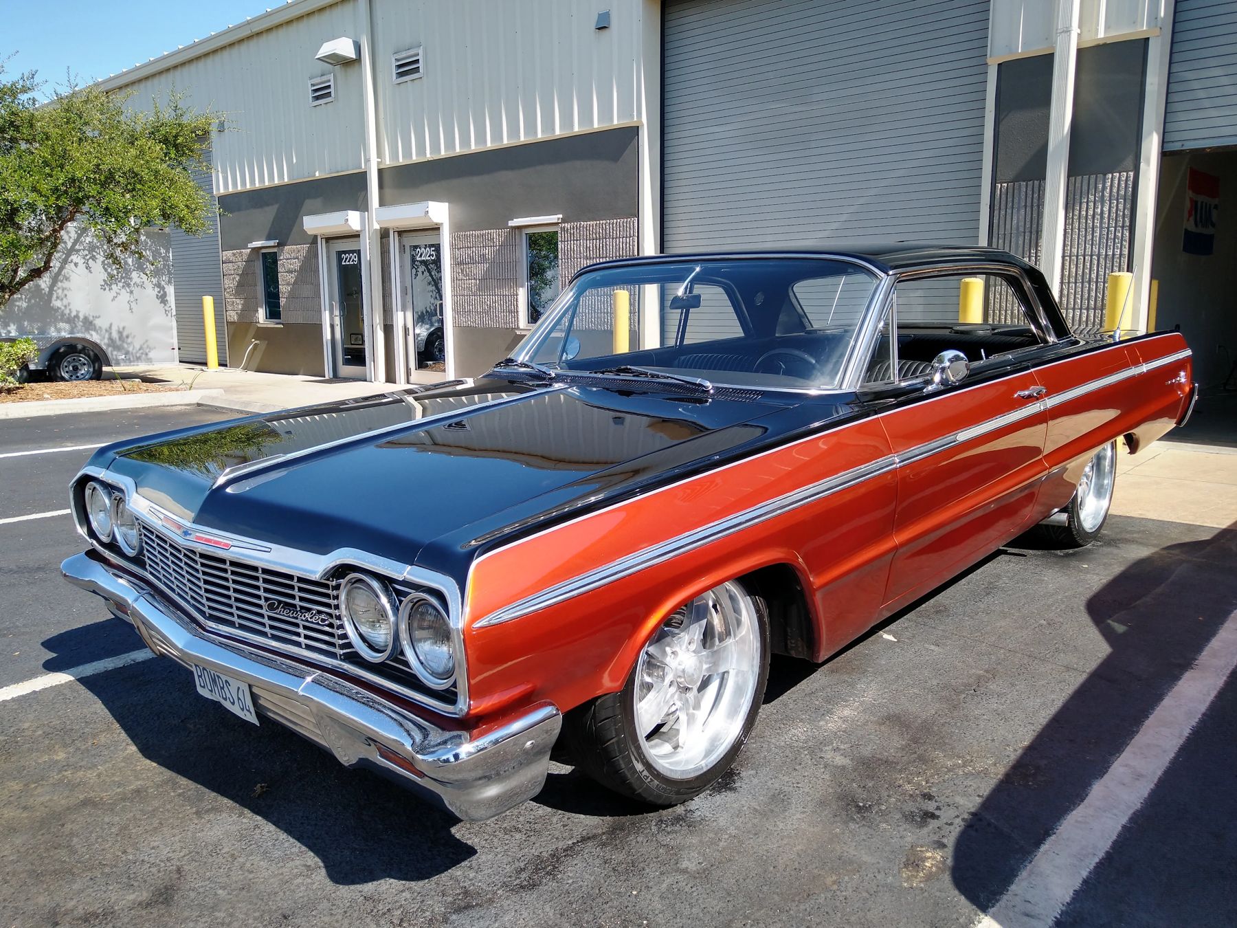 A two-tone Impala outside the workshop